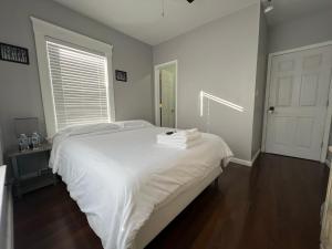 克利夫兰Stay with Jay Cleveland One的一间卧室配有一张带白色床单的床和一扇窗户。