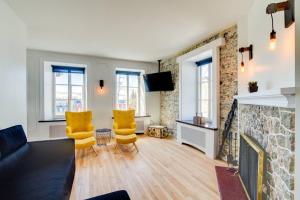 魁北克市La Maison Grenier La Résidence Beauport的客厅配有2把黄色椅子和壁炉