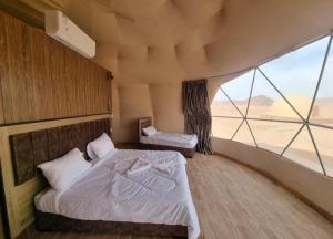 瓦迪拉姆Karam Wadi Rum camp的一间卧室设有两张床和大窗户