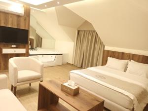 拜特龙Batroun boutique suites的配有一张床和一把椅子的酒店客房