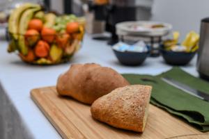 拉绍德封法国酒店的一块带两块面包和一碗水果的切板
