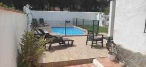 科尼尔-德拉弗龙特拉Villa Conil的一个带椅子的庭院和一个游泳池