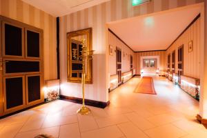 SzprotawaPałac Wiechlice - Hotel, Restaurant, SPA的走廊设有瓷砖地板和镜子