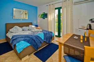 赫瓦尔Villa Softic的一间拥有蓝色墙壁的卧室,配有一张床和一张桌子