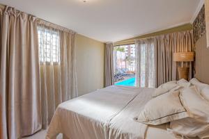 洛斯克里斯蒂亚诺斯Villa 4bed private pool en Los Cristianos的卧室配有白色的床和窗户。