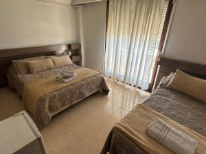 皮里亚波利斯卢汉酒店的酒店客房设有两张床和窗户。