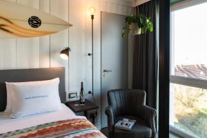 圣彼得奥尔丁Beach Motel St. Peter-Ording的卧室配有床、椅子和窗户。