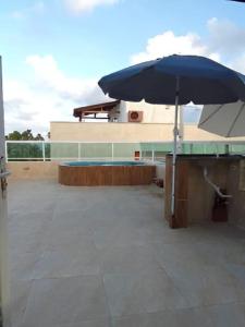 卡博迪圣阿戈斯蒂尼奥Cobertura com vista pro mar的蓝伞,坐在大楼顶