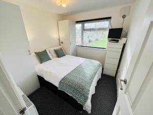 Brading2 Bedroom Chalet SB172, Sandown Bay, Isle of Wight, Free WiFi的一间小卧室,配有床和窗户