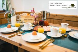 瓦尔道拉Residenz Erschbaum的餐桌,盘子上放着食物和咖啡