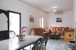 马拉喀什Private Villa halal 2 rooms swimming pool not overlooked的客厅配有桌子和沙发