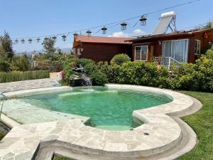 TotolapanVillarreal Lodge Hotel Ecológico的一座房子的庭院里,有一个喷泉的游泳池
