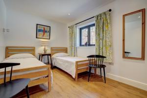 哈勒斯登Contemporary Barn Waveney Valley的一间卧室设有两张床和窗户。