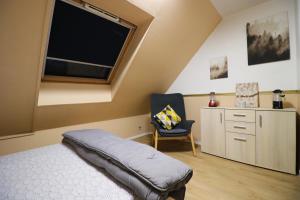 古桑维尔Nov Sweety Home的卧室配有床、椅子和窗户。