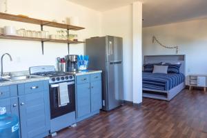 PescaderoEXPERIENCE的厨房配有蓝色橱柜、冰箱和1张床