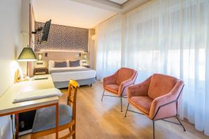 帕伦西亚旧卡斯蒂利亚酒店的酒店客房配有一张床铺、两张椅子和一张书桌