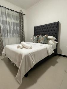卢萨卡Silverest Sanctuary: Home away from Home的卧室配有一张带白色床单和枕头的大床。