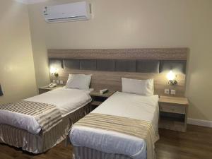 Ash Shishahفندق نزهة النسيم的酒店客房配有两张床和一张书桌