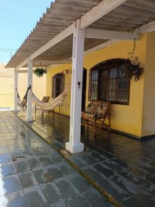 蒙加瓜Casa aconchegante beira mar的房屋内带吊床的门廊