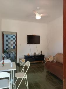 蒙加瓜Casa aconchegante beira mar的客厅配有沙发和墙上的电视
