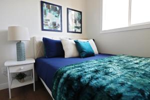 埃德蒙顿Downtown 5 Bedroom,Rogers,Commonwealth,NAIT的一间卧室配有一张带蓝色毯子的床