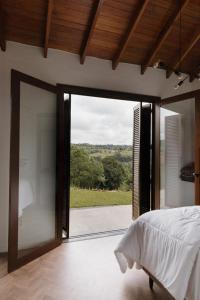 本图贡萨尔维斯Cabanas Vinsanto的一间卧室设有一张床和一个大型玻璃门