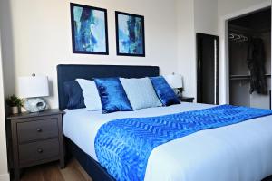 埃德蒙顿Downtown 5 Bedroom,Rogers,Commonwealth,NAIT的一间卧室配有蓝色和白色的床以及两张照片