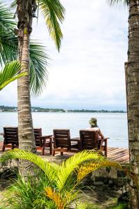博卡斯德尔托罗PirateArts Experience Resort的坐在水边长凳上的人