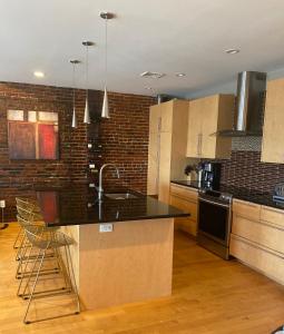 波士顿Boston North end Harbor View condo. FREE PARKING的厨房配有黑色台面和砖墙