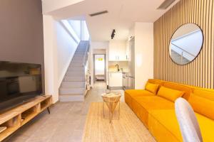 特拉萨Duplex with terrace near Bcn的客厅配有黄色沙发和镜子