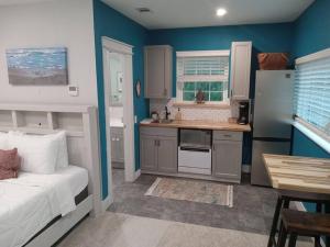 彭萨科拉Studio with Private Beach on Bayou Grande的一间拥有蓝色墙壁的厨房和一张位于客房内的床