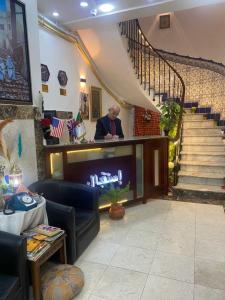 阿尔及尔AFRIC HOTEL- Casbah的坐在酒吧里,在有楼梯的房间里坐着的人