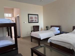 Kundmalir Gold Coast Beach Resort的酒店客房设有两张床和一张桌子。