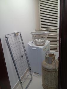 马斯喀特Kayan aprtment2的一间洗衣房,里面装着桶顶的篮子