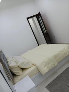 马斯喀特Kayan aprtment2的白色客房的一张床位,配有镜子