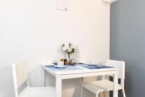 东京FL Residence Asakusa - Vacation STAY 15228的一张带两把椅子的白色桌子和花瓶