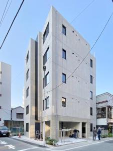 东京FL Residence Asakusa - Vacation STAY 15228的街道上的建筑物,前面的人站在