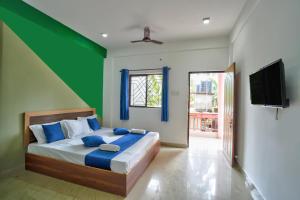 卡兰古特Abbi's Nest Beach House Goa的一间卧室配有一张蓝色和绿色的墙壁。