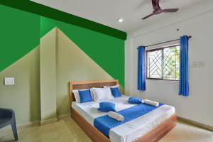 卡兰古特Abbi's Nest Beach House Goa的一间卧室配有一张带绿色墙壁的床