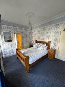 卡纳芬Caer Menai的一间卧室配有蓝色和白色壁纸的床