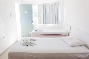 Palmeira dos ÍndiosHotel Grandville III的一间卧室设有两张带白色床单的床和窗户。
