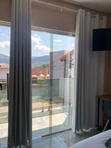伊比科阿拉Pousada Licuri Ibicoara的一间卧室设有大窗户,享有游泳池的景色