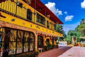 瓜达拉哈拉Posada las Margaritas的街道上带阳台的黄色建筑
