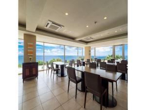 宇流麻Hotel Hamahigashima Resort - Vacation STAY 10570v的用餐室设有桌椅和窗户。