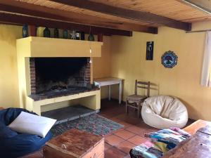 Treinta y TresEl Refugio en la Quebrada的客厅设有砖砌壁炉和椅子