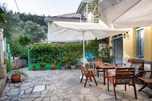 阿约斯尼奇塔斯Hotel Selini的庭院配有桌椅和遮阳伞。