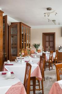 卡莱扎诺拉韦雷塔酒店的用餐室配有白色的桌子和木椅