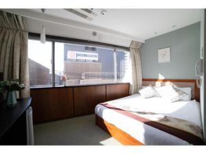 东京Tabata Oji Hotel - Vacation STAY 89820v的一间卧室设有一张床和一个大窗户