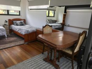 科夫斯港Coffs Harbour Sanctuary的一间带桌子和床的用餐室以及一间卧室