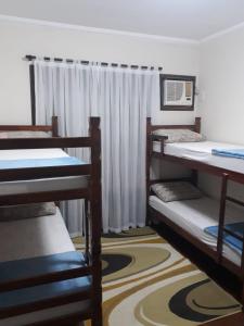 布卢梅瑙Blu Hostel的客房设有三张双层床和一扇窗户。